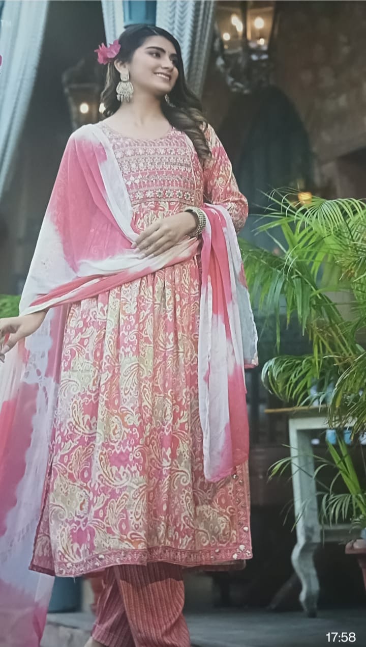 Pink and white traditional outfit with a floral headpiece, standing outdoors in cotton rayon.