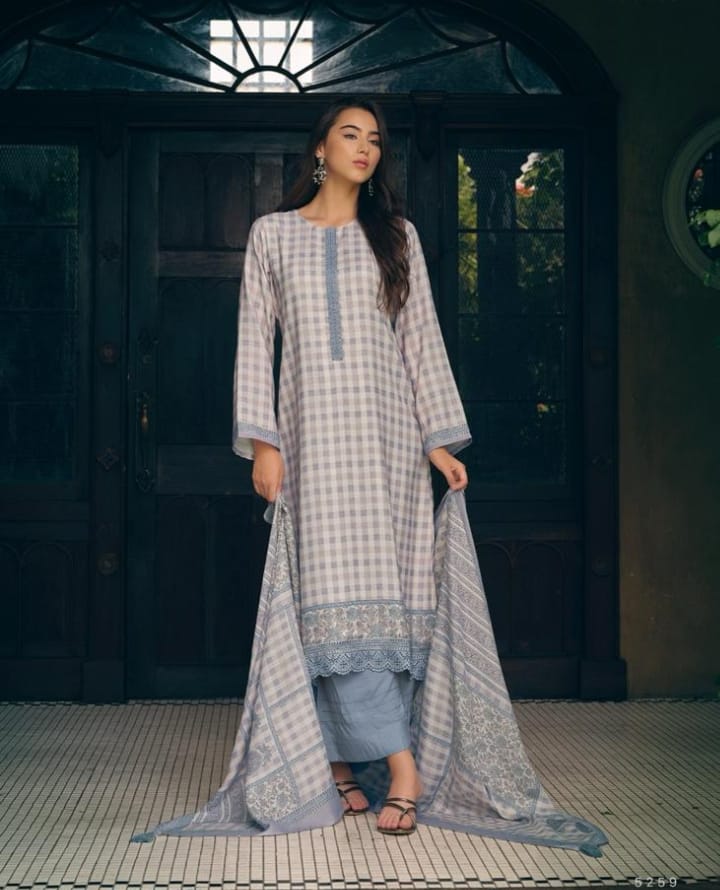 Woman wearing a long, light blue and white checkered dress with a dark background