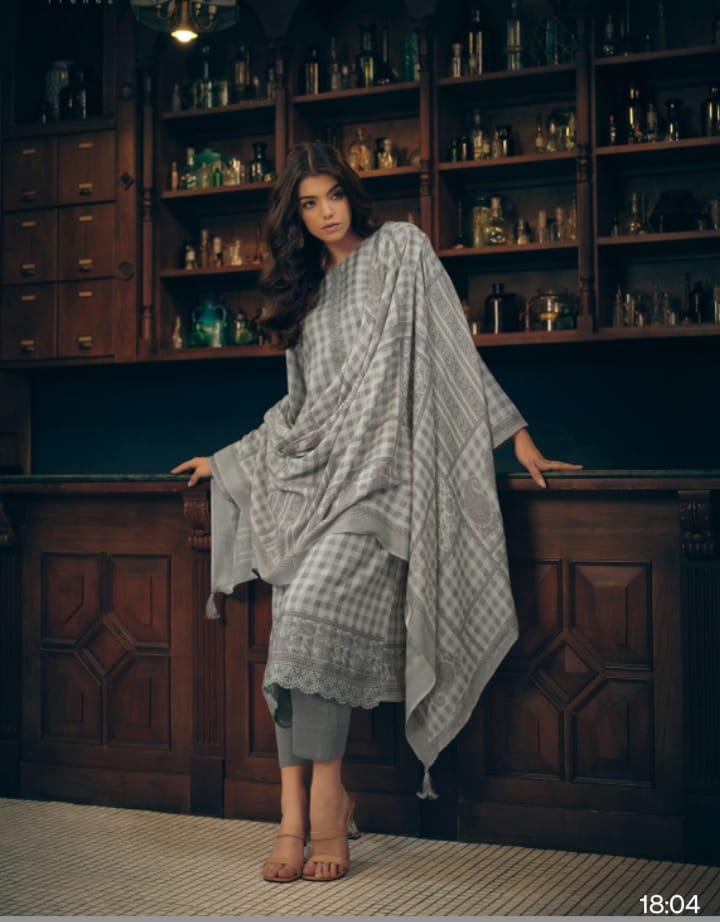 Woman in a patterned dress standing in a room with wooden shelves filled with jars.