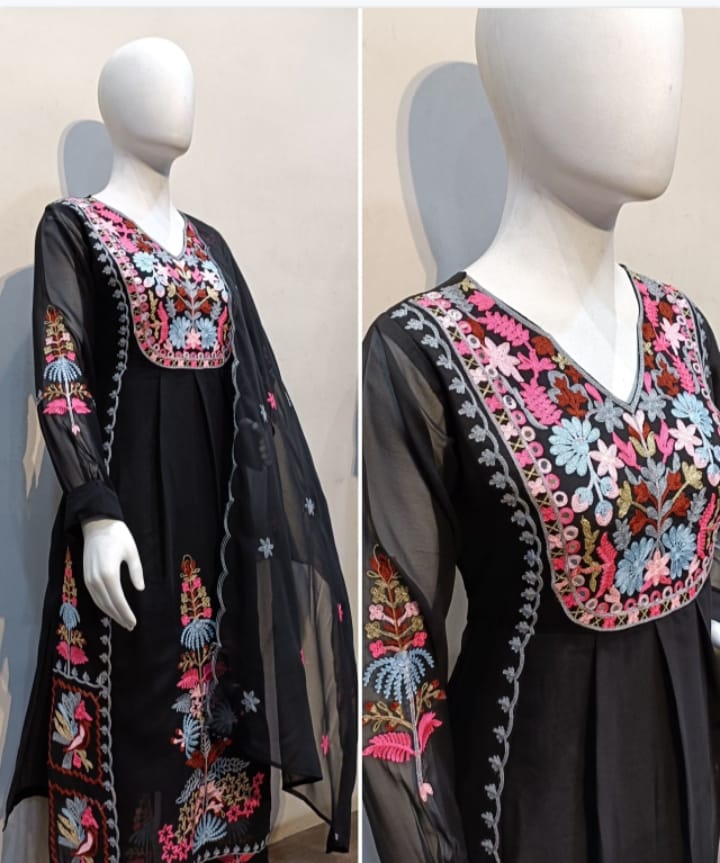 Black dress with colorful floral embroidery on a mannequin against a neutral background